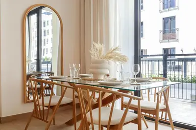 a dining room with a table with chairs and a mirror at HiGuests - Luxurious Boho Beach 2BR Apartment in La Mer in Dubai