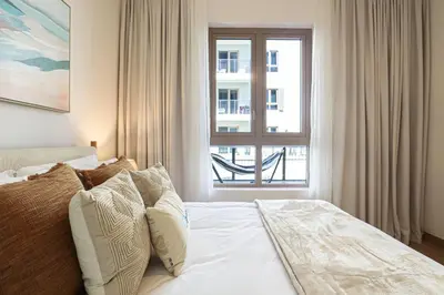 a bedroom with a bed and a large window at HiGuests - Luxurious Boho Beach 2BR Apartment in La Mer in Dubai