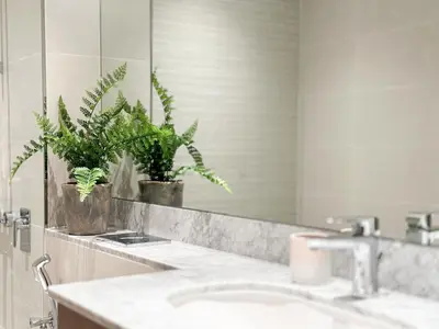 a bathroom with a sink and a mirror and plants at HiGuests - Luxurious Boho Beach 2BR Apartment in La Mer in Dubai