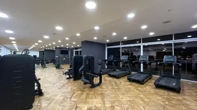 a gym with rows of treadmills and elliptical machines at SmartStay at Zaya Hameni - Modern Luxury Apartments - Unique in JVC in Dubai
