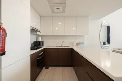a kitchen with white cabinets and a sink at SmartStay at Zaya Hameni - Modern Luxury Apartments - Unique in JVC in Dubai