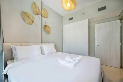 a bedroom with a large white bed with white sheets at 1BR Apartment in Zada Tower Business Bay - Close to Metro in Dubai