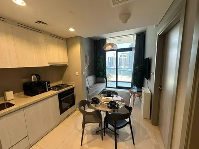 a kitchen with a table and chairs in a kitchen at 1BR Apartment in Zada Tower Business Bay - Close to Metro in Dubai