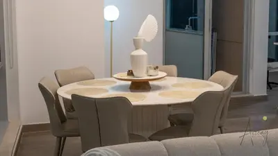 a dining room table with chairs and a vase on it at Top-Floor Luxury 2BR with Stunning Marina View in Dubai