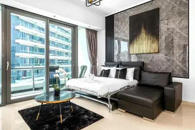 a bedroom with a bed and a couch and a table at Panoramic 1BR Stunning Marina Views Near JBR Beach by Maxx Value Homes in Dubai