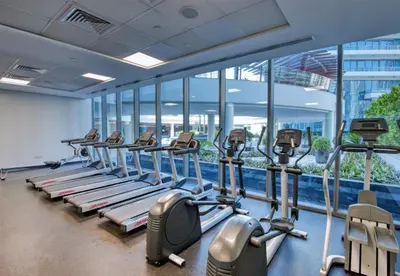 a gym with a row of treadmills at Panoramic 1BR Stunning Marina Views Near JBR Beach by Maxx Value Homes in Dubai