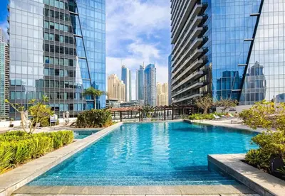a pool in the middle of a city with tall buildings at Panoramic 1BR Stunning Marina Views Near JBR Beach by Maxx Value Homes in Dubai