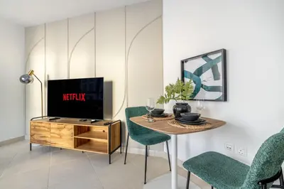 a living room with a tv and a table and chairs at GuestReady - A Dream Getaway at Business Bay in Dubai