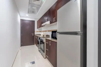 a kitchen with wooden cabinets and a refrigerator at GuestReady - A Dream Getaway at Business Bay in Dubai