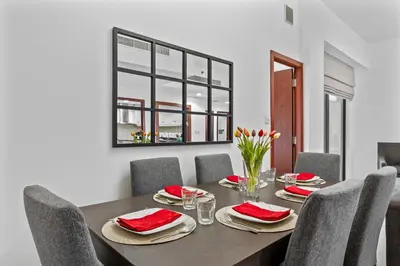 a dining room with a table with red napkins and chairs at Prime Spacious 5 plus 1 BR Apt on JBR Beach near Metro ,Walk to The Mall, Dining & Entertainment - By Sunkissed Holiday Homes in Dubai