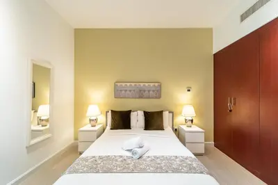 a bedroom with a large bed with two night stands at Prime Spacious 5 plus 1 BR Apt on JBR Beach near Metro ,Walk to The Mall, Dining & Entertainment - By Sunkissed Holiday Homes in Dubai