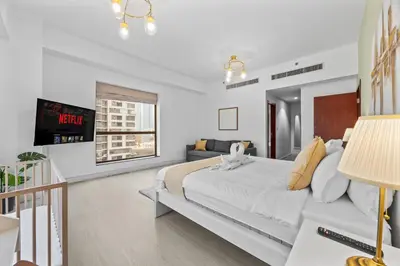 a white bedroom with a bed and a couch at Prime Spacious 5 plus 1 BR Apt on JBR Beach near Metro ,Walk to The Mall, Dining & Entertainment - By Sunkissed Holiday Homes in Dubai
