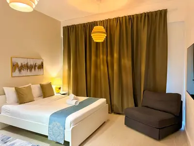 a bedroom with a bed and a chair at Prime Specious 4 BR Apt on JBR Beach near Metro, Walk to The Mall, Dining & Entertainment - By Sunkissed Holiday Homes in Dubai