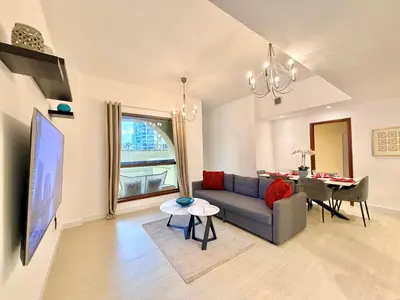 a living room with a blue couch and a table at Prime Specious 4 BR Apt on JBR Beach near Metro, Walk to The Mall, Dining & Entertainment - By Sunkissed Holiday Homes in Dubai