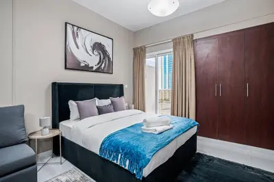 a bedroom with a bed and a chair and a window at Hidden Gem - Comfort And Family Friendly in Dubai