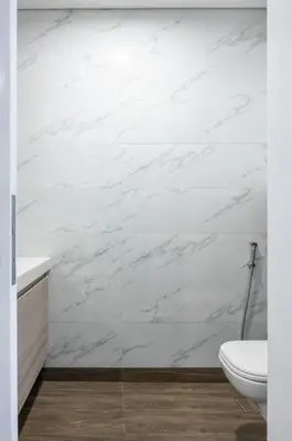 a bathroom with white marble walls and a toilet at DAYF-SOL Luxury Living in Business Bay in Dubai