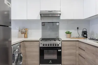a kitchen with white cabinets and a stove top oven at DAYF-SOL Luxury Living in Business Bay in Dubai