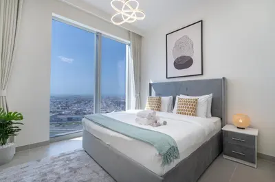 a bedroom with a large bed and large windows at Heaven Crest Vacation Homes - Luxury Forte in Dubai