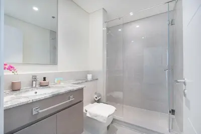 a bathroom with a shower and a toilet and a sink at Heaven Crest Vacation Homes - Luxury Forte in Dubai