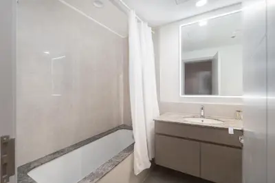 a bathroom with a tub and a sink and a mirror at Heaven Crest Vacation Homes - Luxury Forte in Dubai
