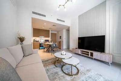 a living room with a couch and a flat screen tv at SettlerHomes - Marvelous Lagoon Stay With Pool View in Dubai