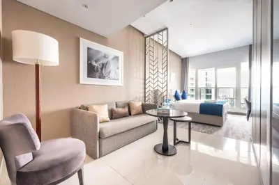 a living room with a couch and a table and a bed at Studio Apartment in DAMAC Maison Prive Business Bay - High Floor in Dubai