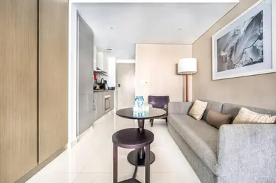 a living room with a couch and a table at Studio Apartment in DAMAC Maison Prive Business Bay - High Floor in Dubai
