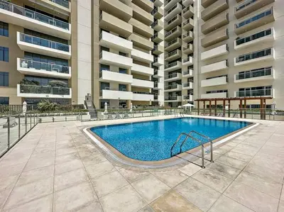 a swimming pool in front of a large building at Stylish 1 BR in Al Furjan in Dubai