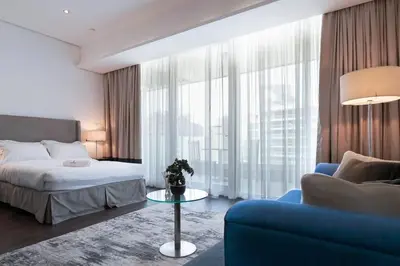 a bedroom with a bed and a blue couch at Cozy Studio in Sports City in Dubai