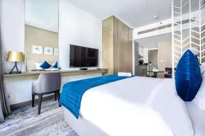 a hotel room with a large bed and a television at Studio Apartment in DAMAC Maison Prive Businessbay - Dubai Canal View in Dubai