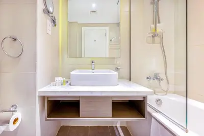 a bathroom with a sink and a tub and a mirror at Studio Apartment in DAMAC Maison Prive Businessbay - Dubai Canal View in Dubai