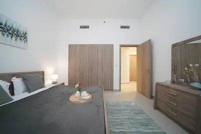 a bedroom with a large bed and a table at Spacious 1 BR in Peaceful Community in Dubai