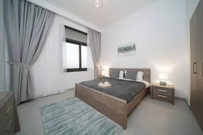a bedroom with a large bed and a window at Spacious 1 BR in Peaceful Community in Dubai