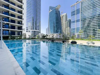 a swimming pool in a city with tall buildings at Zada Tower 1BR with amazing Dubai Canal view in Dubai