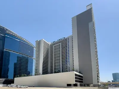 a tall building with a crane on top of it at Zada Tower 1BR with amazing Dubai Canal view in Dubai