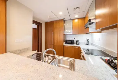 a kitchen with wooden cabinets and a sink at EDEN'S Homes & Villas - Standpoint Residences in Dubai