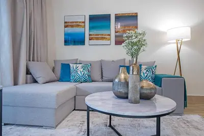 a living room with a couch and two vases on a table at Stylish 2BR with Balcony Near Dubai Mall and Burj Khalifa in Dubai