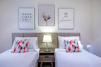 two beds in a room with pictures on the wall at Stylish 2BR with Balcony Near Dubai Mall and Burj Khalifa in Dubai