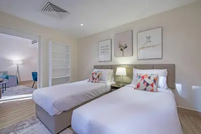 a bedroom with two beds and a living room at Stylish 2BR with Balcony Near Dubai Mall and Burj Khalifa in Dubai