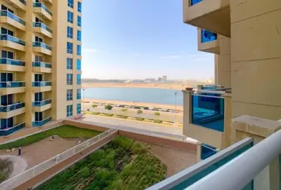 a balcony of a building with a view of the ocean at Cozy Furnished Studio in Dubai