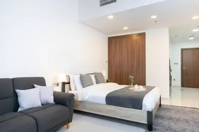a bedroom with a bed and a couch at Furnished Cozy Studio in Dubai