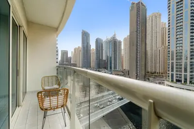 a balcony with a chair and a view of a city at FIRST CLASS 2BR with Exquisite Full Marina View in Dubai
