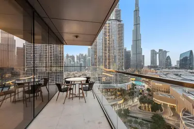 a balcony with tables and chairs and a view of a city at Modern 2BR with Harbor Views, Pool, & Concierge in Dubai