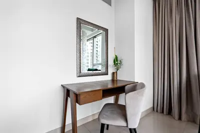a desk with a mirror and a chair in a room at Modern 2BR with Harbor Views, Pool, & Concierge in Dubai