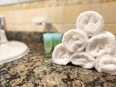a pile of towels sitting on a bathroom counter at Amazing Sea View 2 bedroom Full Apartment in Dubai