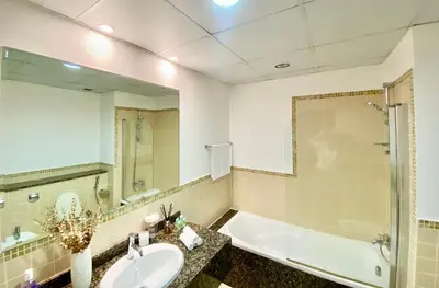 a bathroom with a sink and a tub and a mirror at Amazing Sea View 2 bedroom Full Apartment in Dubai