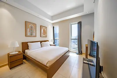 a bedroom with a bed and a flat screen tv at 1BR + maid room Apartment in Downtown Dubai in Dubai