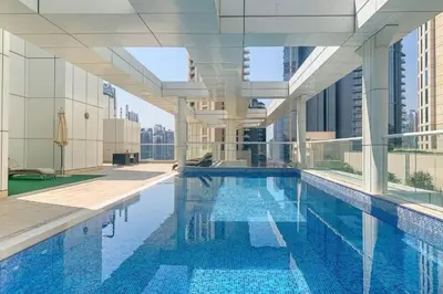 a large swimming pool in a building with a building at 1BR + maid room Apartment in Downtown Dubai in Dubai