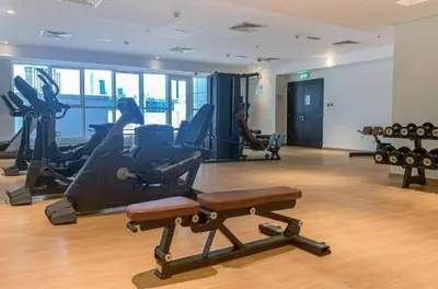 a gym with treadmills and exercise equipment in a building at 1BR + maid room Apartment in Downtown Dubai in Dubai