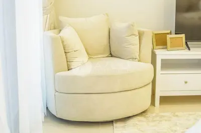 a white chair sitting in a living room next to a table at Elegant Studio at Aykon City Tower - C in Dubai